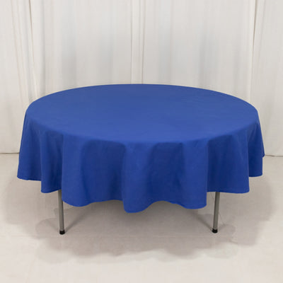 Round blue tablecloth draped over a table in a studio setting.