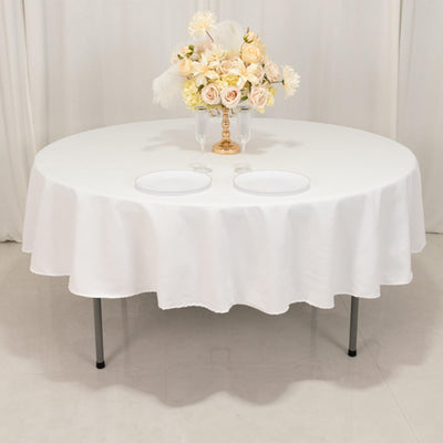 Round table with white tablecloth and floral centerpiece.