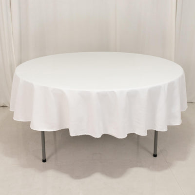 Round white table with a draped tablecloth, studio shot.