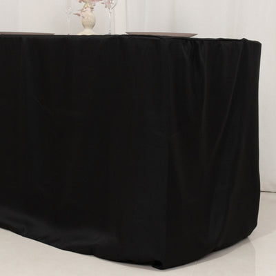 Black tablecloth draping over a table for elegant event decor.