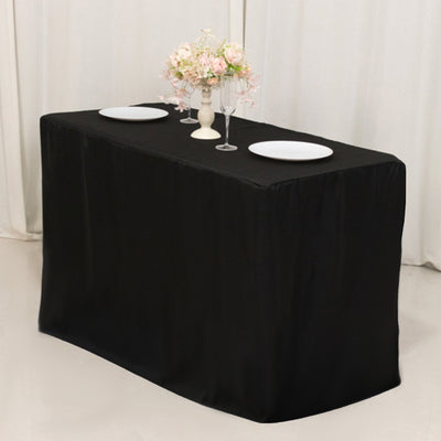 Elegant black tablecloth draped over a table set for dinner with floral centerpiece.