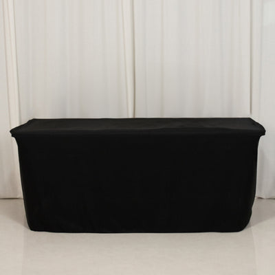Black table cover on a plain backdrop.