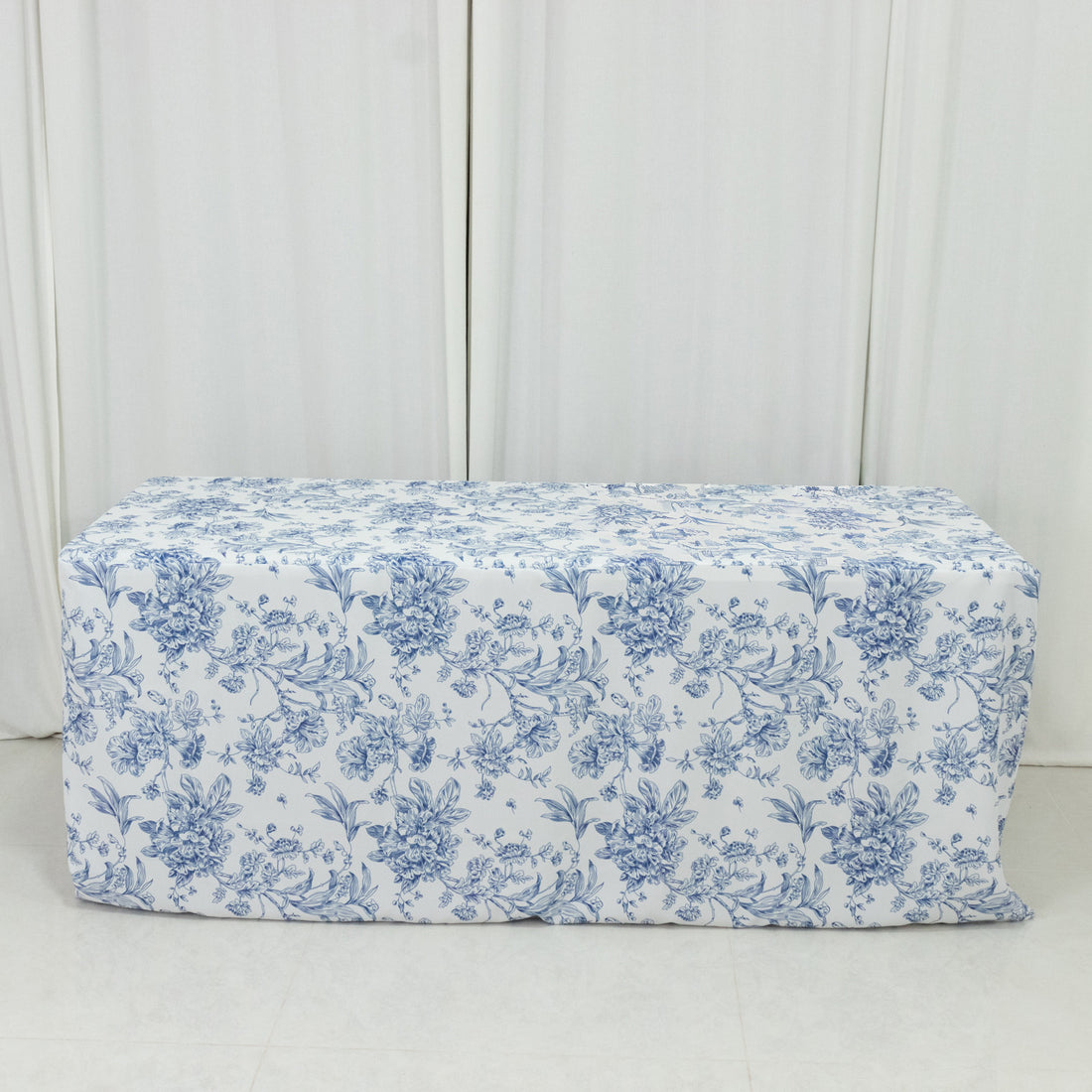 Floral-patterned tablecloth on a table in a bright setting.