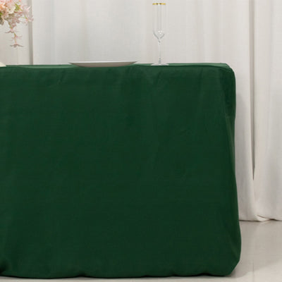Green tablecloth draped over a table in a simple setting.