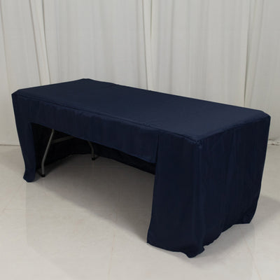 Navy blue tablecloth draped over a folding table on a plain background.