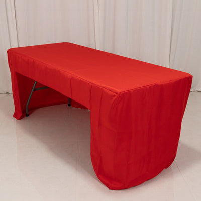 Red tablecloth draped over a folding table in a studio setting.