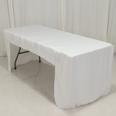 White table with draped tablecloth in a studio setting