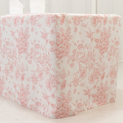Floral tablecloth with pink and white design covering a table corner.