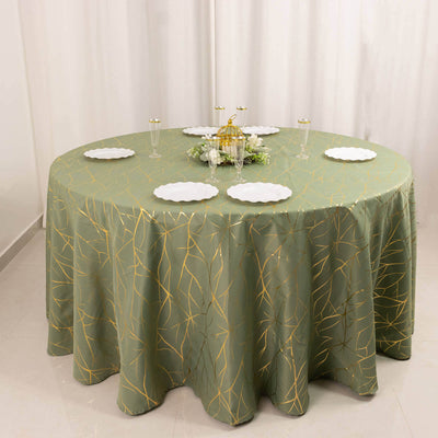 Green round tablecloth with gold leaf pattern on a dining table setting.