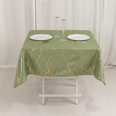 Green tablecloth with golden leaf design on a dining table setup.
