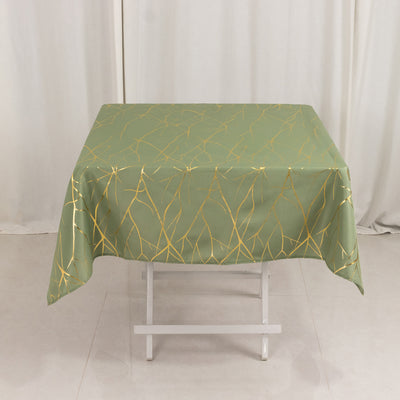 Green tablecloth with gold abstract pattern on a folding table.