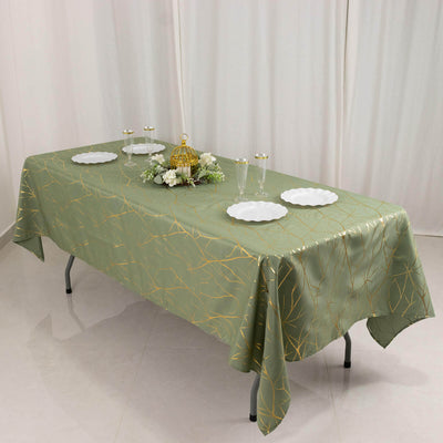 Elegant green tablecloth with gold pattern on a dining table setup.