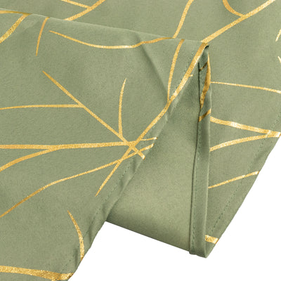 Green tablecloth with gold leaf design, folded corner view.