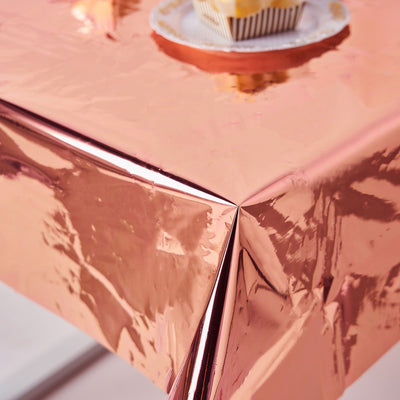 Rose gold metallic table cover with creases and reflections.