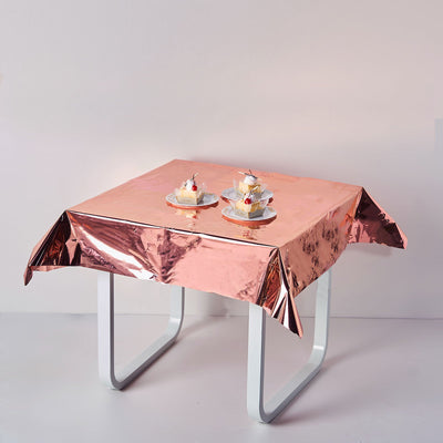 Rose gold tablecloth on a table with cupcakes.