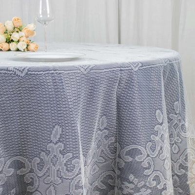 Lace tablecloth draped elegantly over a round table with floral centerpiece.