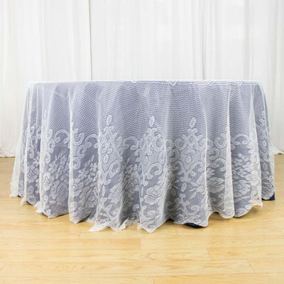Elegant lace tablecloth draping over a table in a bright setting.