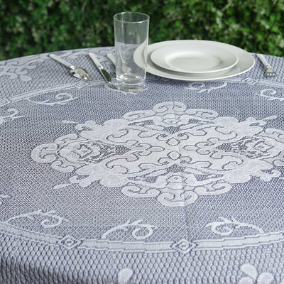 Decorative round tablecloth with intricate design on a dining table setting.