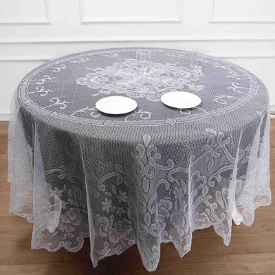 Elegant lace tablecloth with intricate design on a round table.