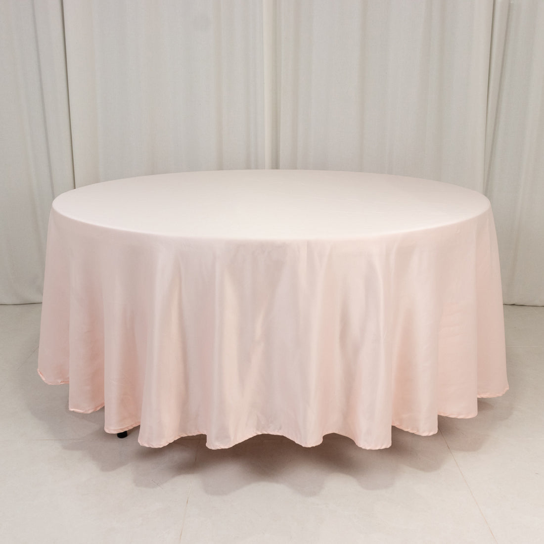Round pink tablecloth draped elegantly on a circular table