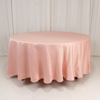 Round pink tablecloth draped over a table in a studio setting.