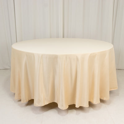 Round beige tablecloth on a plain backdrop.