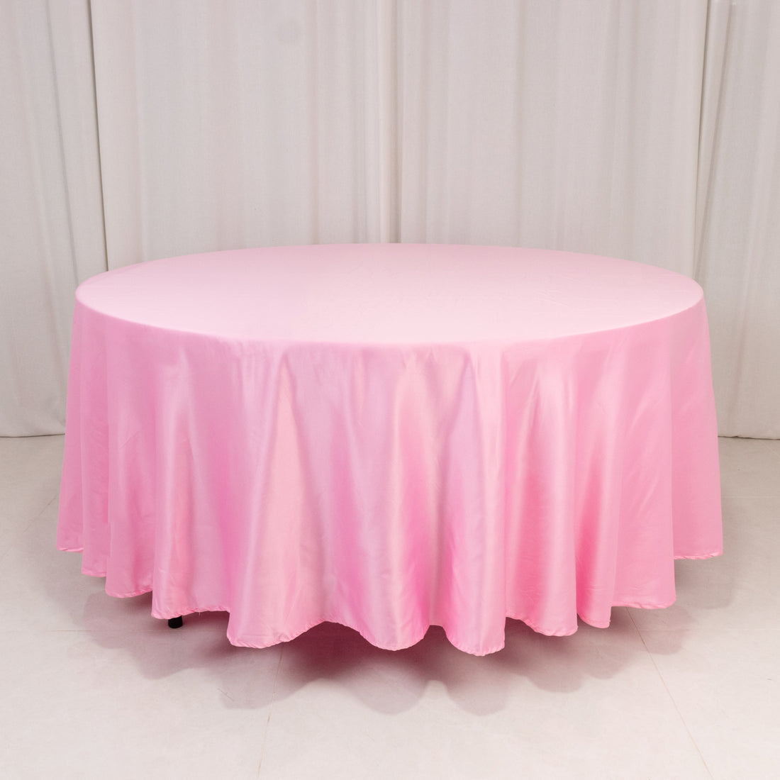 Round pink tablecloth draping elegantly over a circular table