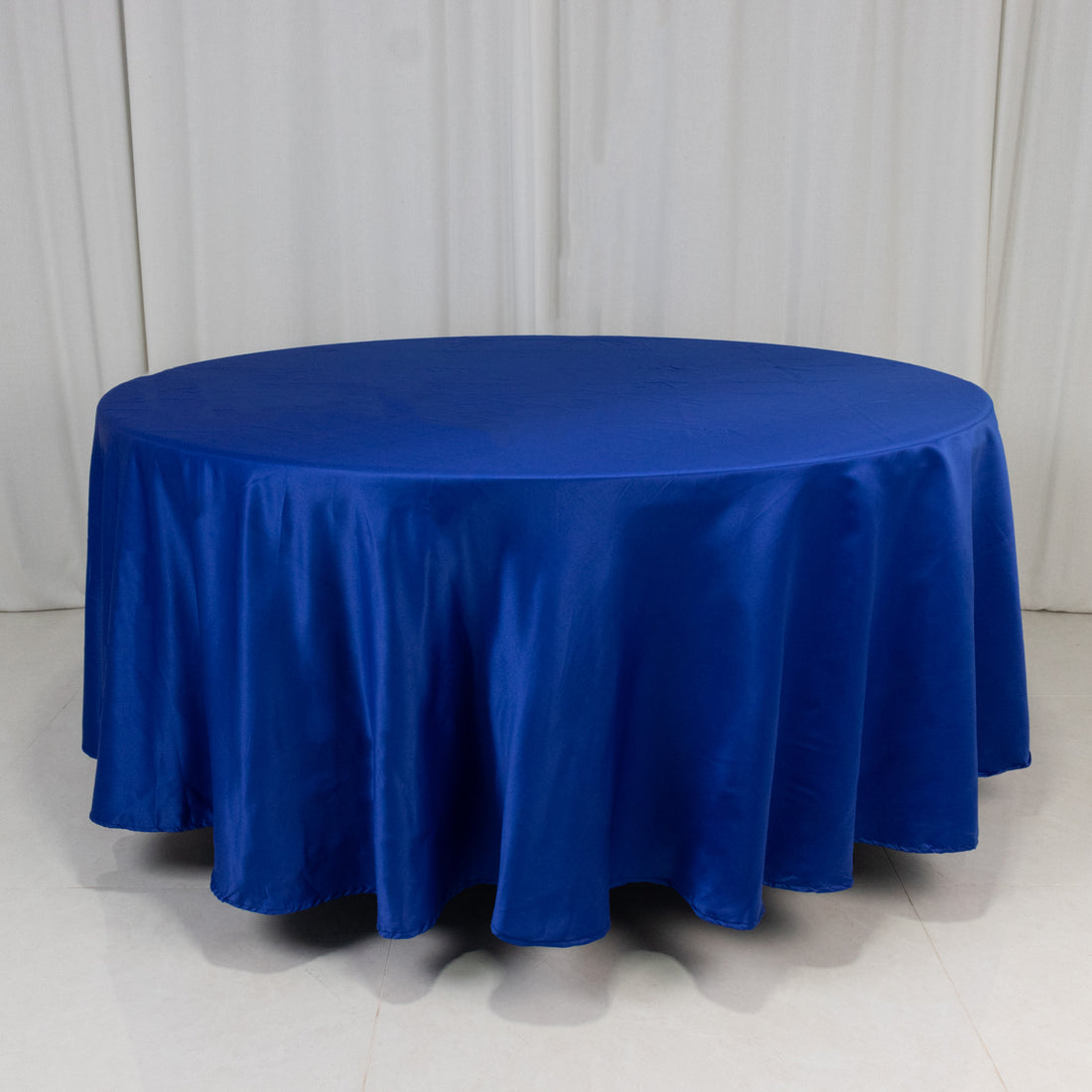 Round blue tablecloth with elegant satin finish on a white backdrop.