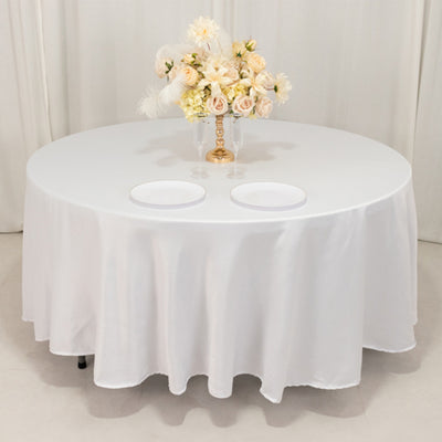 Round table with white tablecloth and floral centerpiece.