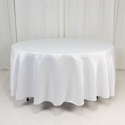 Round white table with a smooth tablecloth in a studio setting