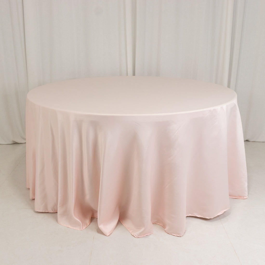 Round pink tablecloth draped elegantly on a round table.