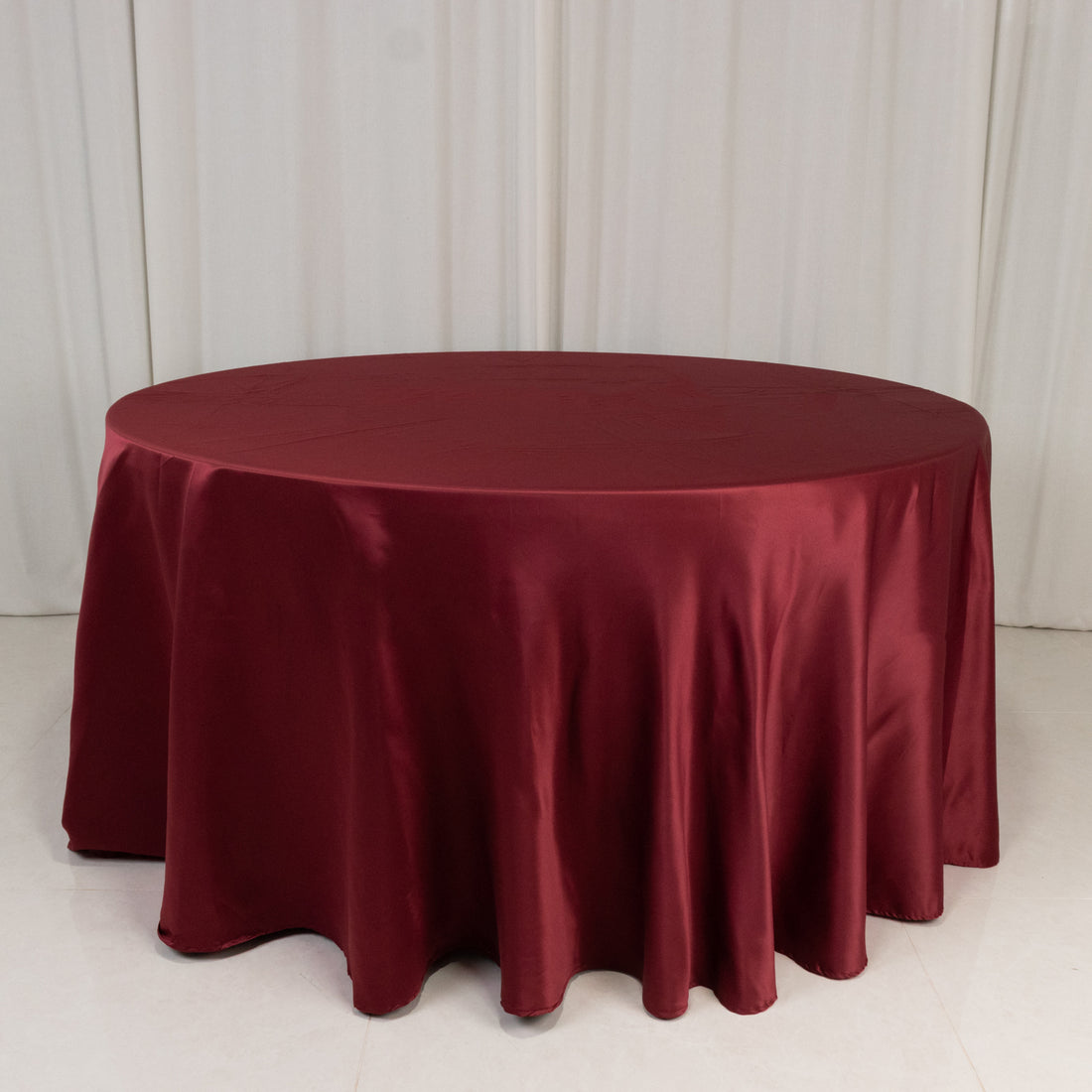 Burgundy round tablecloth draping elegantly over a table