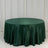 Green satin tablecloth draped over a round table in a studio setting.