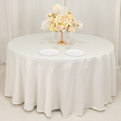 Elegant round table with white tablecloth and floral centerpiece.