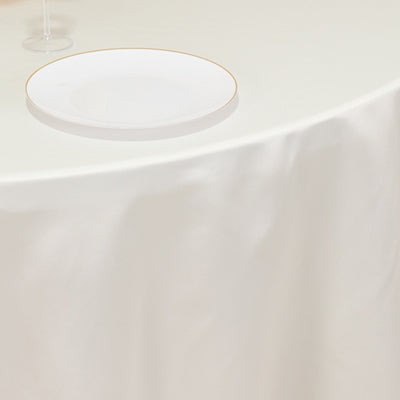 Elegant white table setting with a gold-rimmed plate and wine glass.