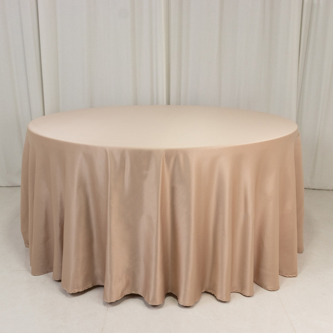 Round beige tablecloth draping elegantly over a circular table.