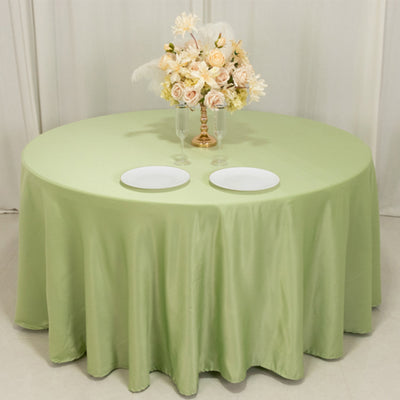 Round green tablecloth with floral centerpiece and two white plates.