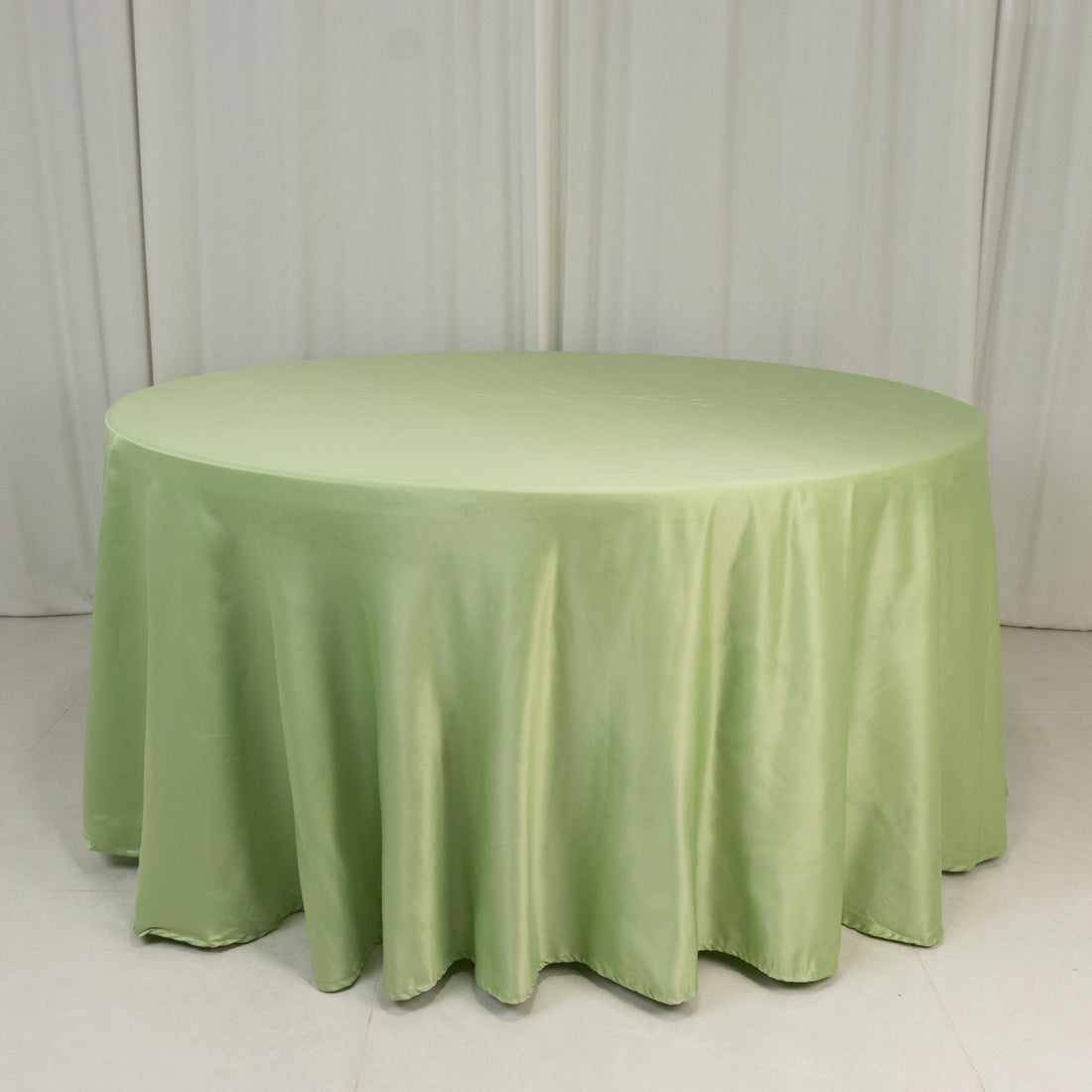 Round green tablecloth on a plain backdrop.