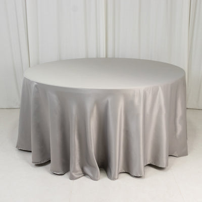 Round table covered with a smooth, silver tablecloth.