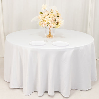 Elegant round table with white tablecloth and floral centerpiece.