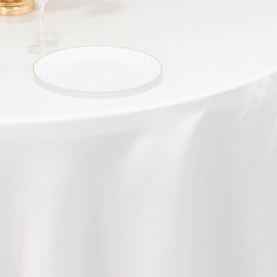 Elegant table setting with a gold vase, wine glass, and a white plate.