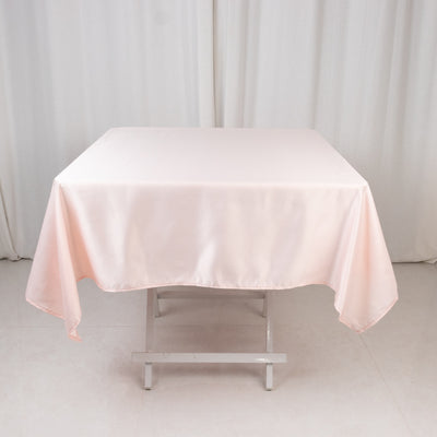 Pink satin tablecloth draped over a table in a studio setting