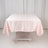 Pink satin tablecloth draped over a table in a studio setting
