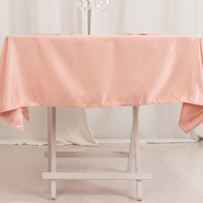 Pink satin tablecloth draped over a white folding table.