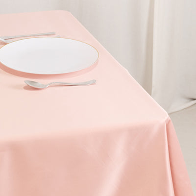 Elegant pink tablecloth with a white plate and silver cutlery.