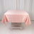 Pink satin tablecloth on a folding table in a studio setting.
