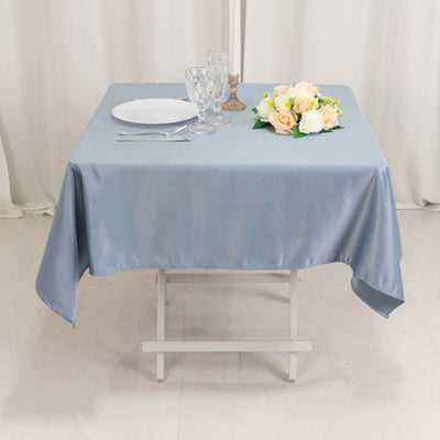 Elegant blue tablecloth with table setting and floral centerpiece.