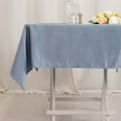 Blue satin tablecloth draped elegantly over a table with floral centerpiece.
