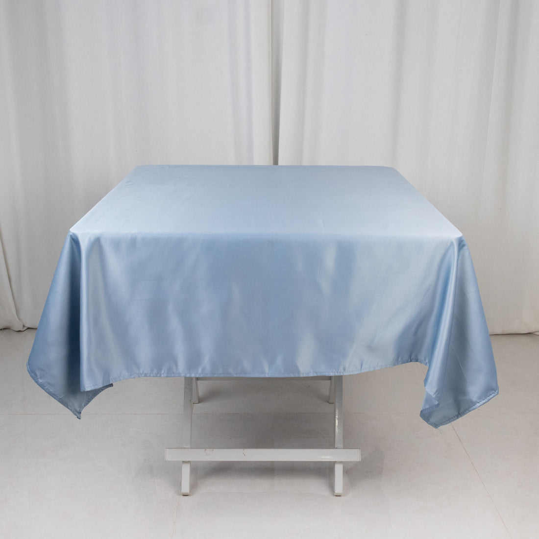 Blue satin tablecloth draped over a white table.