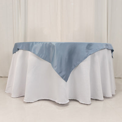 Round table with a white tablecloth and blue satin overlay
